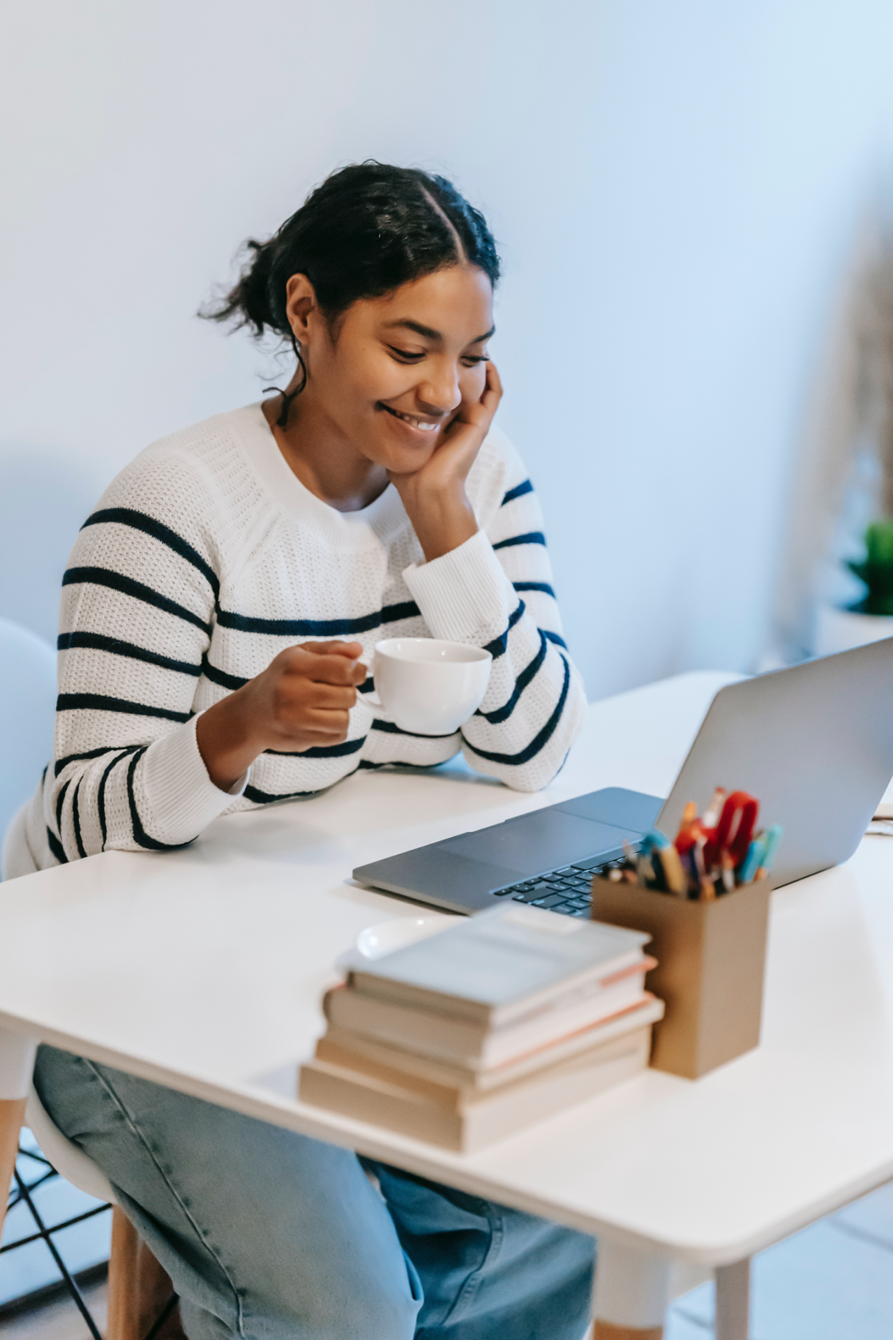Woman smiles at laptop while working on elearning modules.