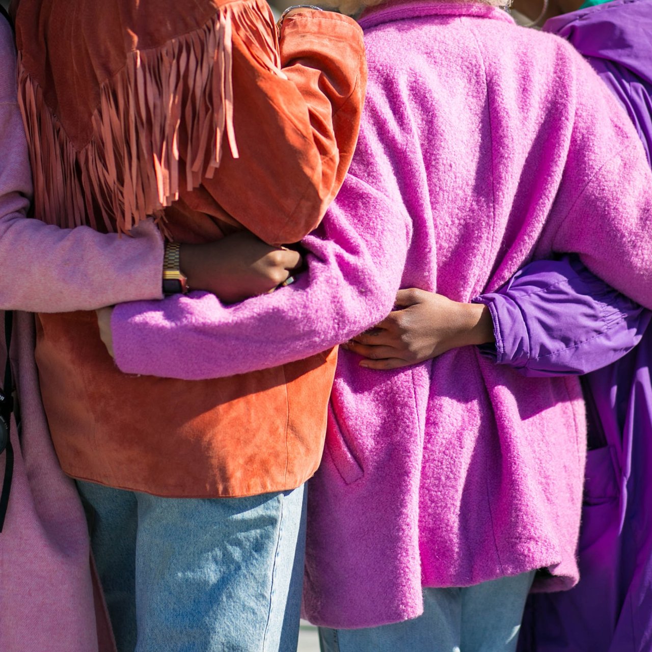 Woman in pink, arms around each other.