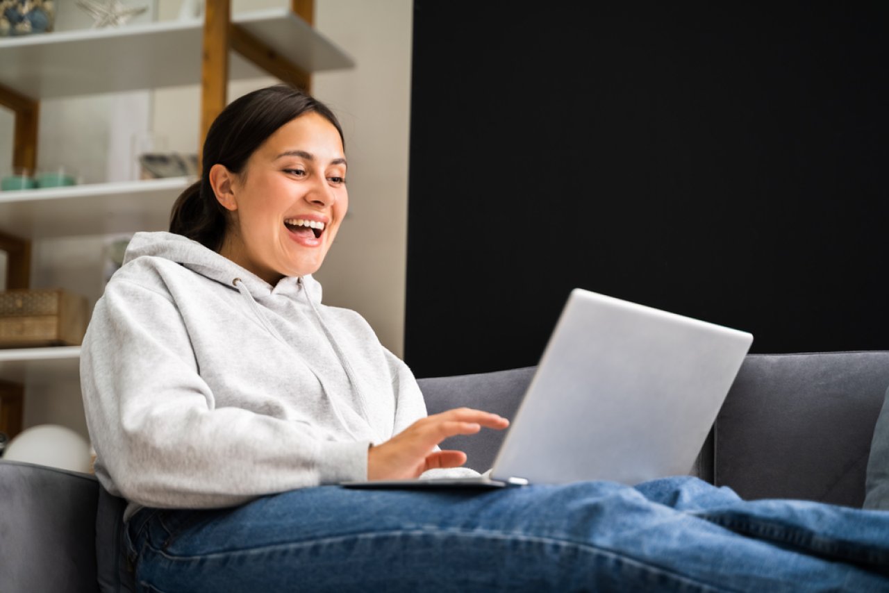 Woman using eLearning on laptop while sitting.